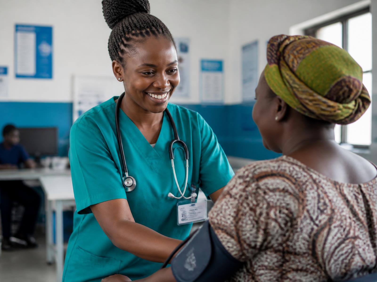 A nurse at Primecare Medical Clinic checking the blood pressure of a smiling patient